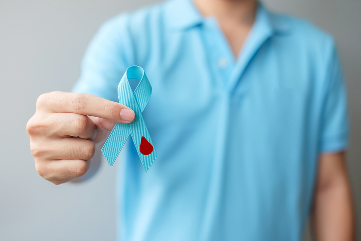 November World Diabetes day Awareness month, man holding light Blue Ribbon with blood drop shape for supporting people living, prevention and illness.