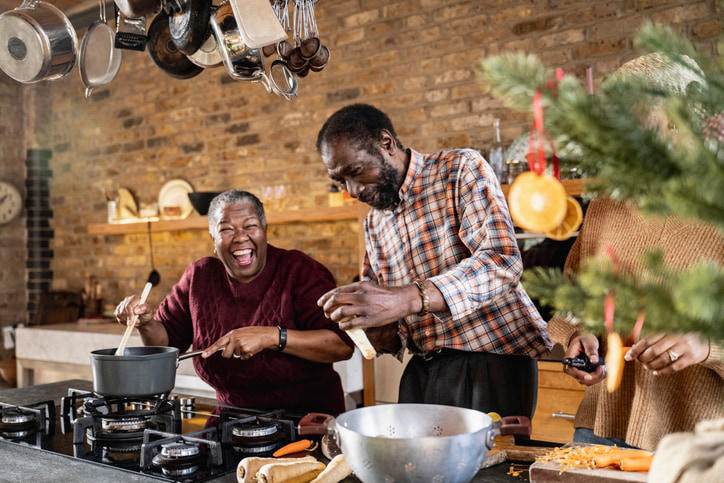 Senior Couple laughing and cooking in a festive kitchen